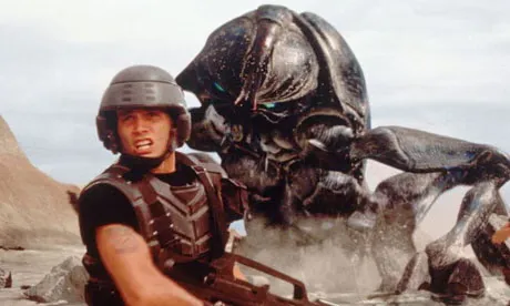 A soldier in a helmet facing a giant bug, a still from Starship Troopers